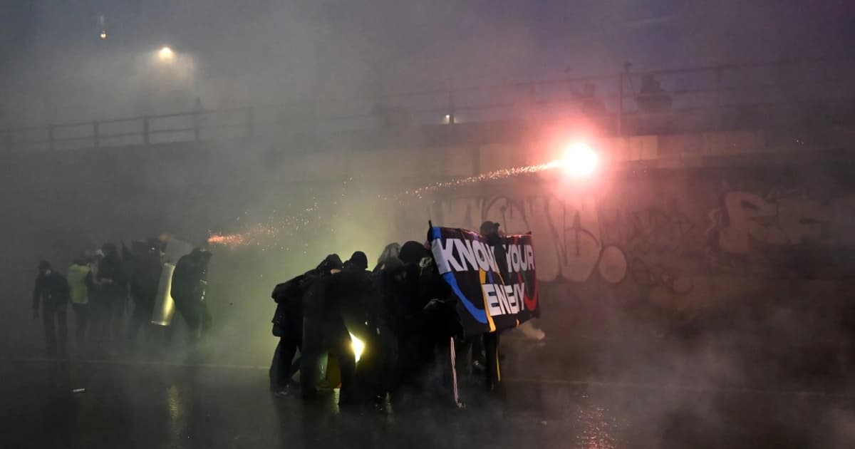 Police fire water cannon at protesters hurling smoke bombs in Milan