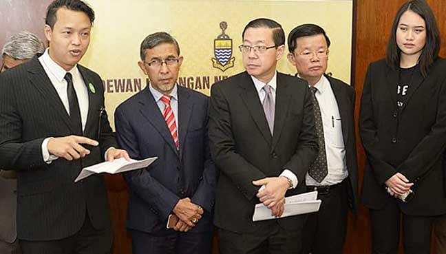 Grab non-Klang Valley head Justin Tiew (left) and Uber Malaysia market executive Natasha Ang Ai Lin (second from right) offering RM5 off all rides in Penang until month's end.