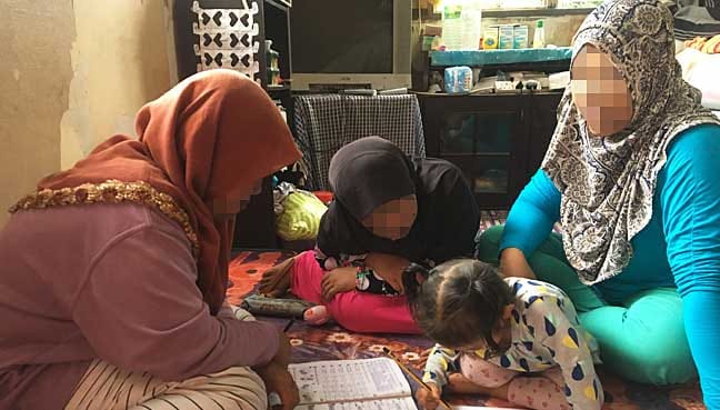 Ridzawati teaching her children as they are eager to learn.