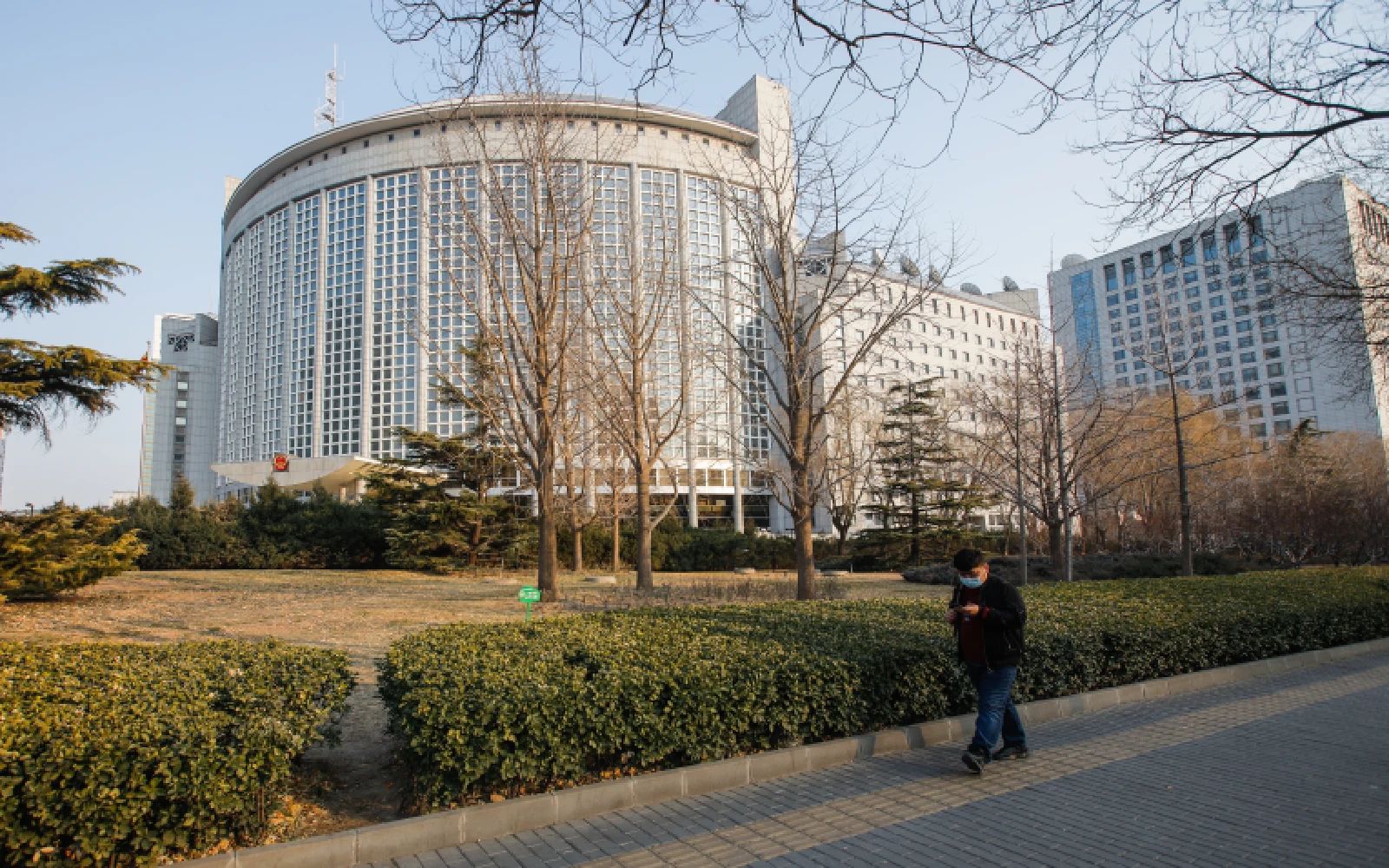 A man wearing a face mask walks in front of the Ministry of Foreign Affairs building in Beijing, China, 07 February 2023.