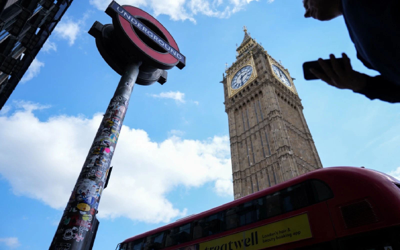 A man walks past a sign for the London Underground in Westminster in central London on April 21, 2026, as significant disruption was expected on "Tube" services as members of the railway workers' union RMT go on strike. (Photo by CARLOS JASSO / AFP)