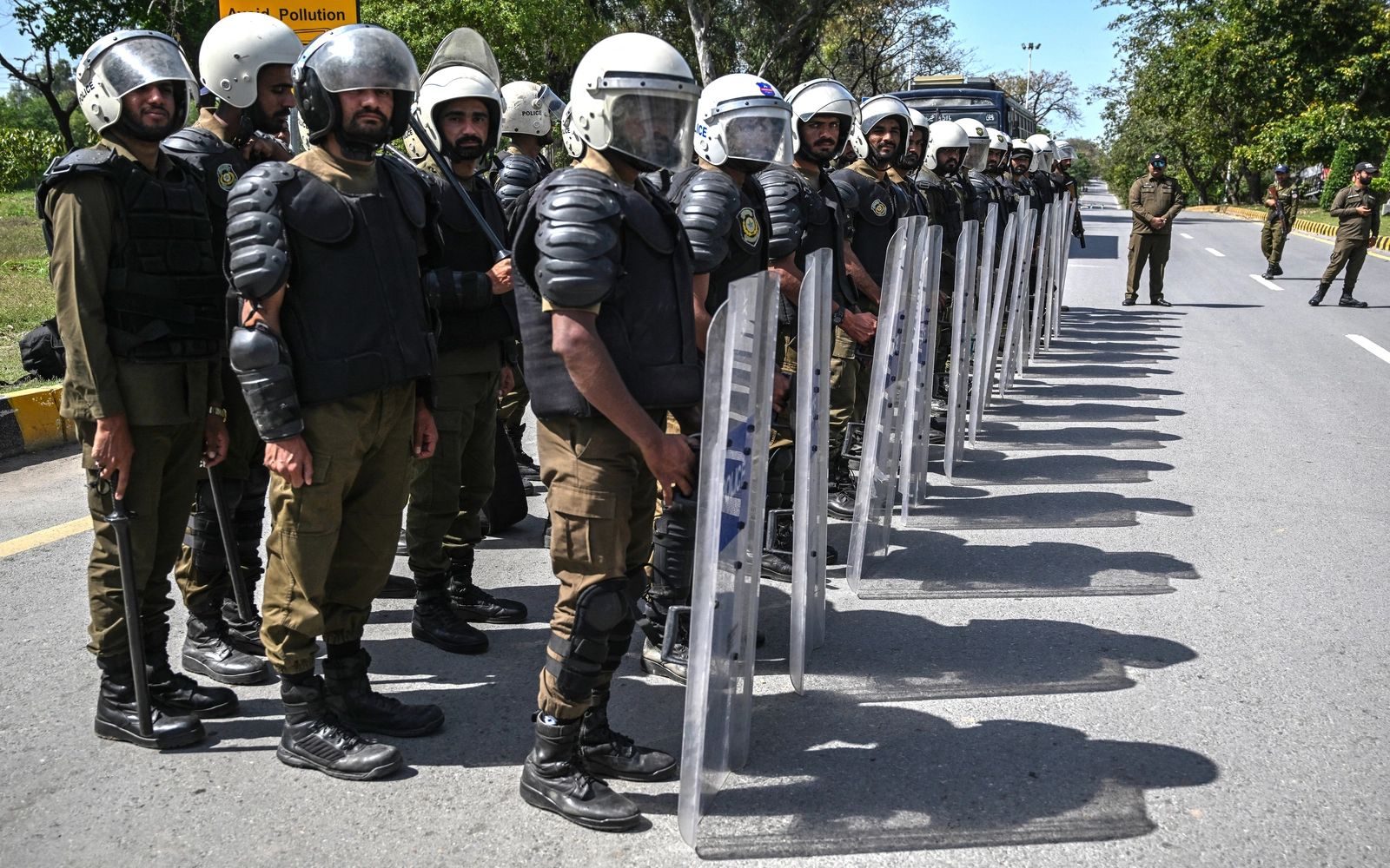Riot policemen line up along a road near the expected venue of the US-Iran talks in the Red Zone area of Islamabad on April 10, 2026. As Iranian and US envoys prepare to hold talks in Islamabad to end the Middle East war, official sources and experts say Beijing helped pave the way for the negotiations and will be a crucial component in securing a permanent truce. Related content