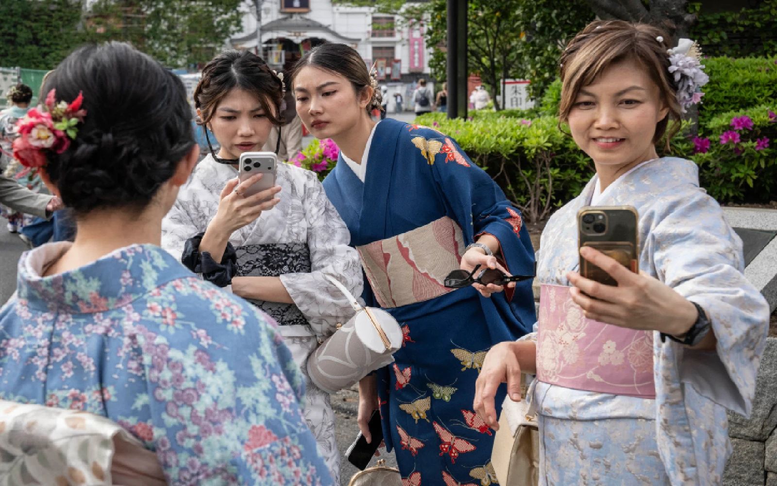 Foreign tourists take selfies in Tokyo’s Asakusa district on April 15, 2026. A record number of tourists visited Japan in March, the official tourism board said on April 15, despite a sharp drop in Chinese visitors after the relationship between Beijing and Tokyo have soured.