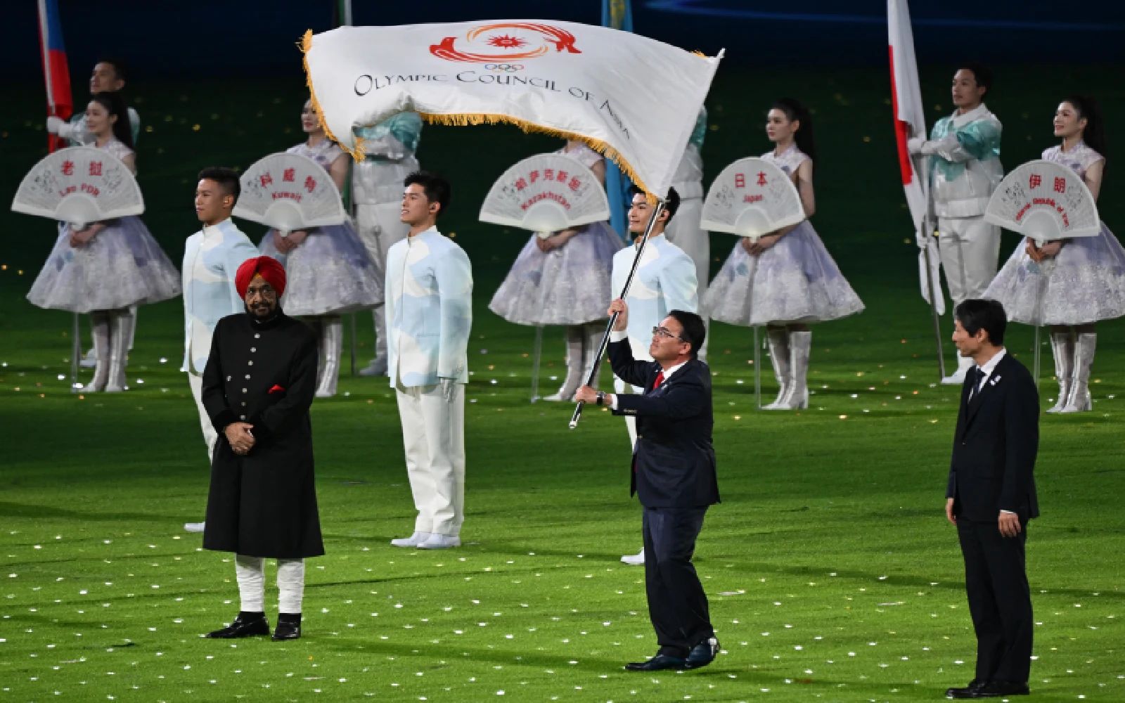 Japan's governor of Aichi prefecture Ohmura Hideaki (C), Japan deputy mayor of Nagoya Nakata Hideo (R) and Acting President of the Olympic Council of Asia Raja Randhir Singh take part in the handover of the flag during the closing ceremony of the 2022 Asian Games at the Hangzhou Olympic Sports Centre Stadium in Hangzhou in China's eastern Zhejiang province on October 8, 2023. (Photo by JUNG Yeon-je / AFP)
