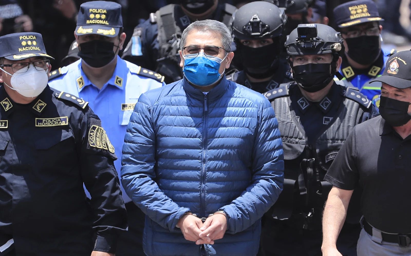 Former Honduran President Juan Orlando Hernandez walks surrounded by police agents during his extradition process at the headquarters of the National Special Forces Directorate, in Tegucigalpa, Honduras, 21 April 2022. Hernandez, accused by the United States of three charges related to drug trafficking and use of weapons, will be extradited to the US on a plane that arrives in Tegucigalpa on the same day. EPA/Gustavo Amador