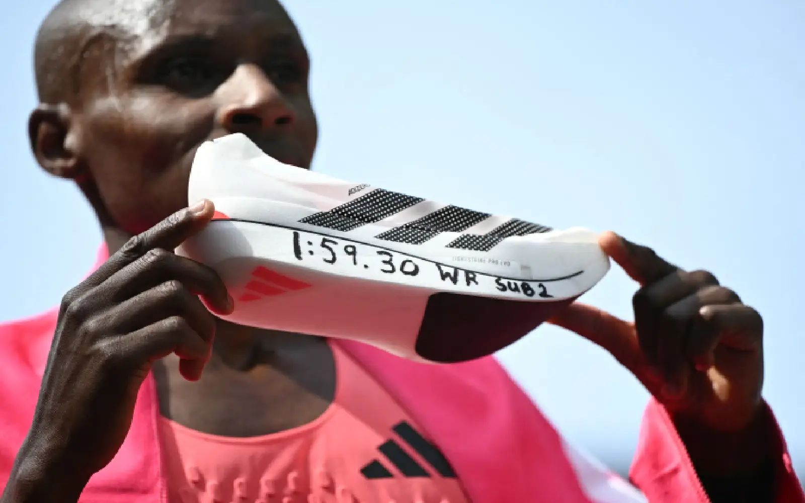 Kenya's Sabastian Sawe poses with his new world record time written on his running shoe at the finish of the 2026 London Marathon in central London on April 26, 2026.