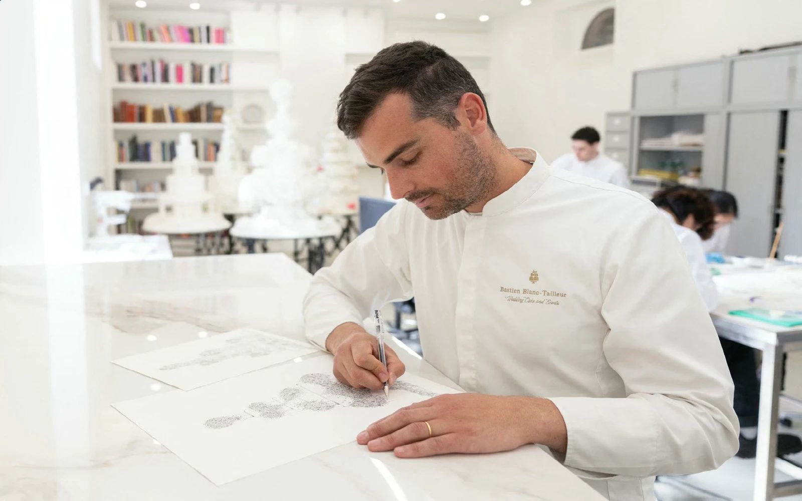 French pastry chef Bastien Blanc-Tailleur designs a wedding cake at his studio in Saint-Remy-les-Chevreuse, southwestern Paris on April 10, 2026.