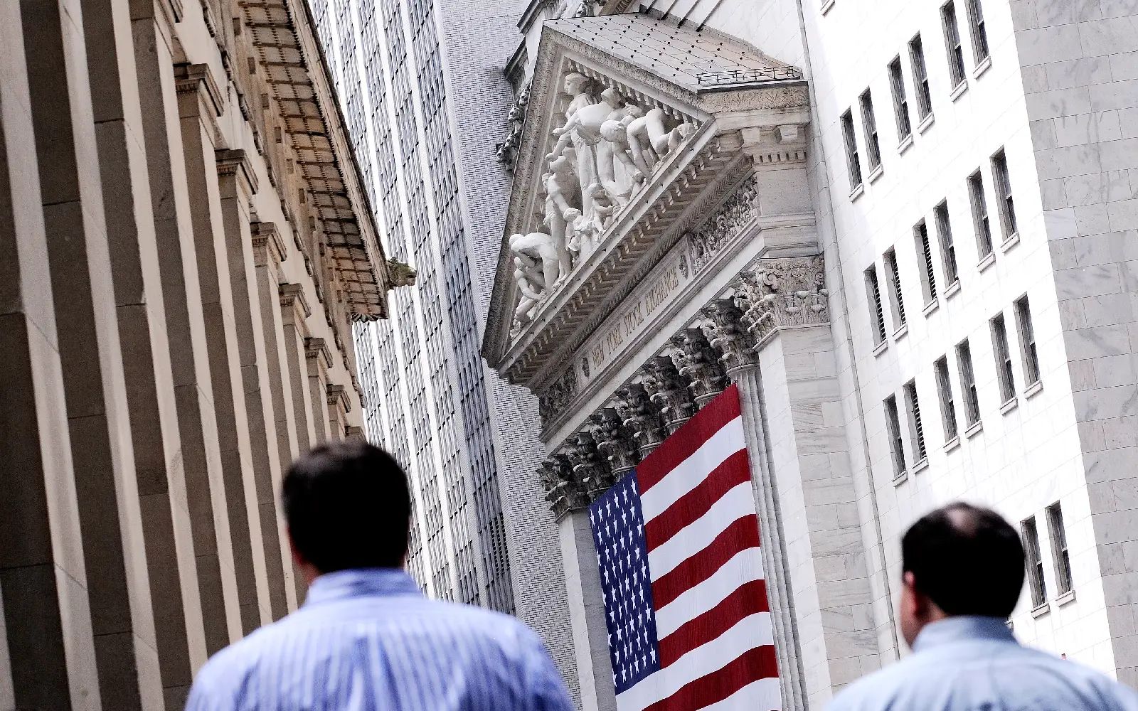 People walk past the New York Stock Exchange in New York, New York, USA, on 08 August 2011. The Dow Jones Industrial average is sharply down following last week's downgrading of the United States' debt. Global share markets were hit by a fresh wave of panic selling 08 August after the weekend downgrade of the US's credit rating compounded worries about the world economic outlook. With stock prices on Wall Street hammered down about 2.7 per cent as the trading finished in Europe, the benchmark Europe Stoxx 600 share index wound up another ugly session down 4.14 per cent at 228.98 points. The market volatility following the announcement late Friday that New York-based rating agency Standard & Poor's had downgraded long-term US debt