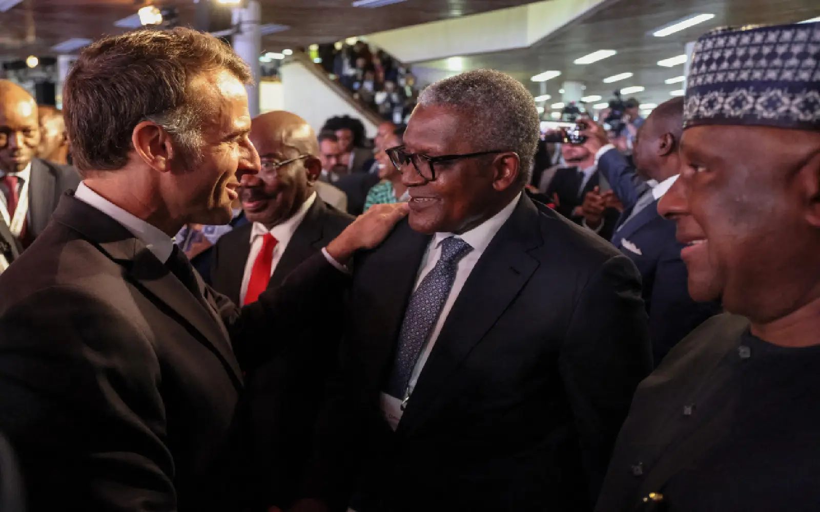 France's President Emmanuel Macron (L) greets Nigerian businessman and Africa's richest man Aliko Dangote (C), during the Africa Forward summit in Nairobi on May 11, 2026. (Photo by Ludovic MARIN / AFP)
