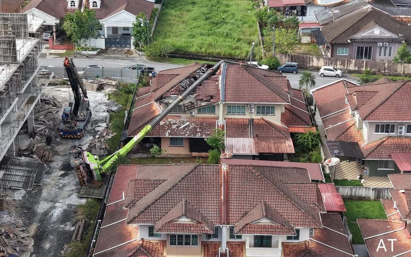 Crane crushes roofs of 2 houses after toppling over in Kuching